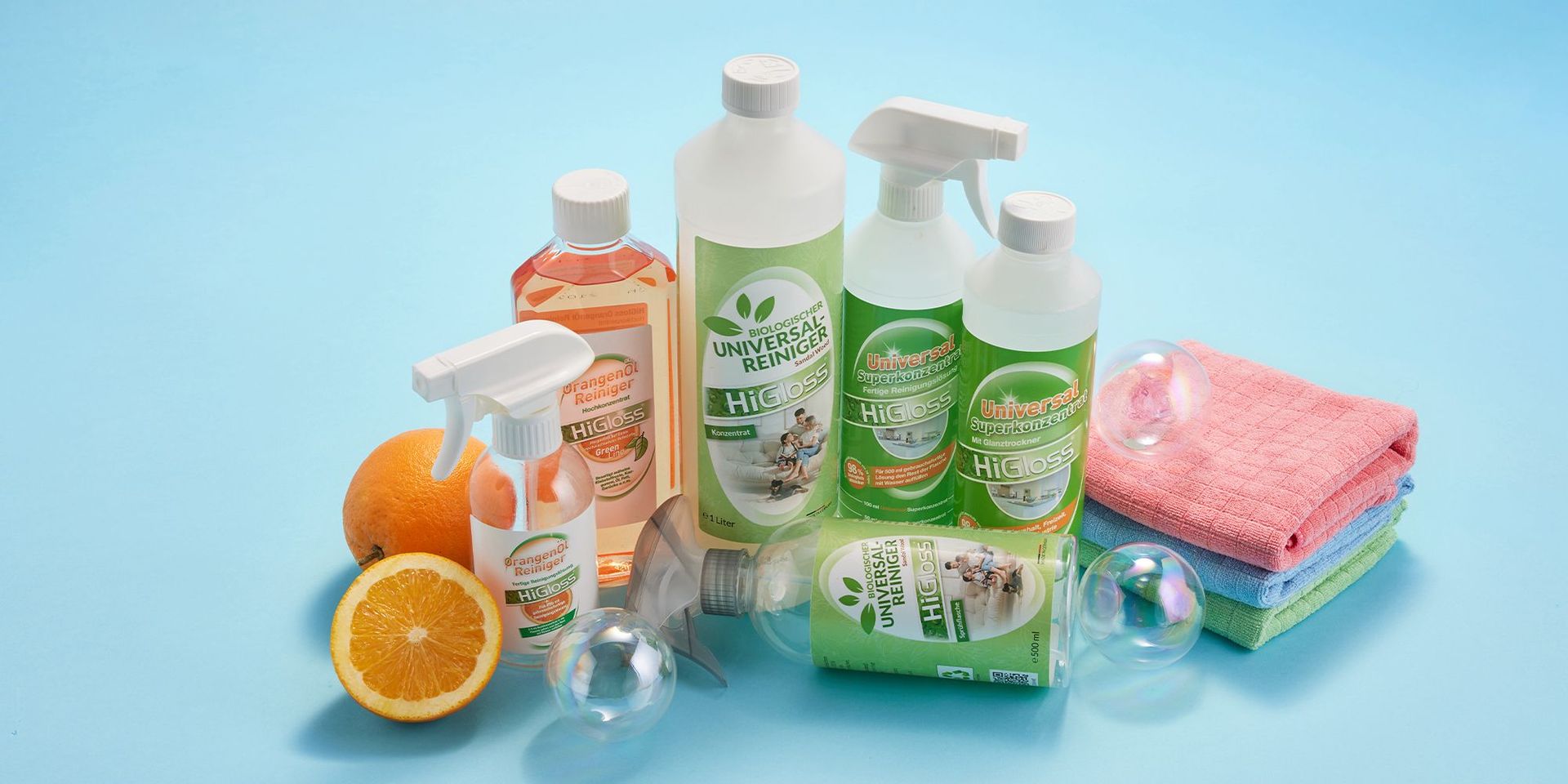 HiGloss Universalreiniger und Orangenölreiniger mit frischen Orangen auf blauem Hintergrund